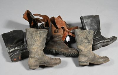 de nombreuses paires de bottes alignées par terre