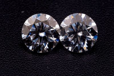 une paire de diamants taille ronde sur un fond noir
