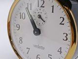 a black and gold alarm clock sitting on a white surface