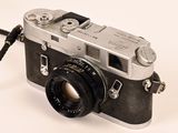 a silver camera with a black strap on it