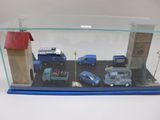 une vitrine en verre contenant de nombreuses petites voitures
