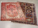 two oriental rugs on display in a room with a white floor