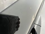 a person holding a remote control on the hood of a car