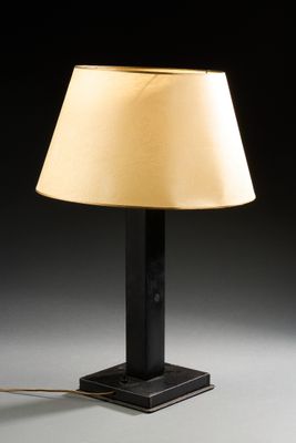 une lampe de table noire surmontée d'un abat-jour beige