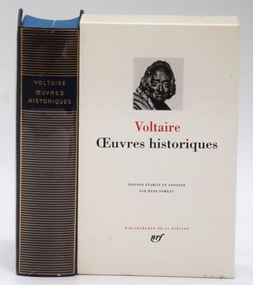 an old book sitting on top of a white table next to a black book