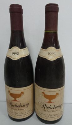 two bottles of wine sitting next to each other on a table
