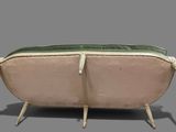 a pink and green couch sitting on a gray surface