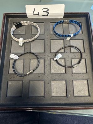 Plusieurs bracelets sont exposés dans une vitrine posée sur une table