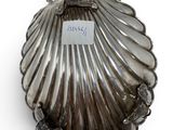 an antique silver shell shaped box with a tag on it