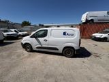une camionnette blanche garée dans un parking à côté d'autres véhicules