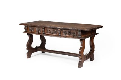 une vieille table en bois dont le plateau est orné de sculptures