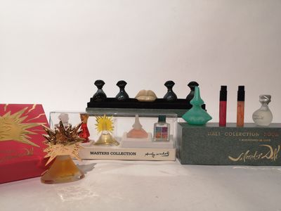 des flacons de parfum et un coffret de parfum posés sur une surface blanche