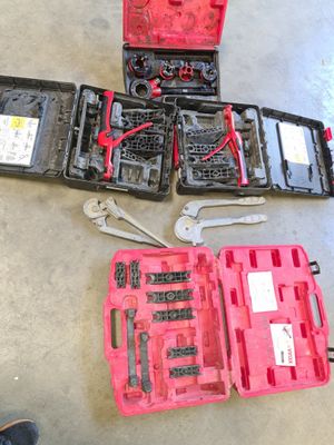 de nombreux outils dans la mallette posée par terre à côté d'une paire de chaussures