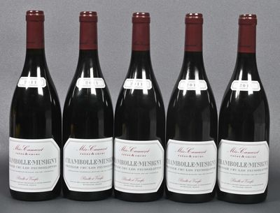 six bottles of red wine are lined up on a table