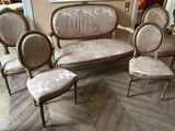 several chairs and a couch in a room with a painting on the wall