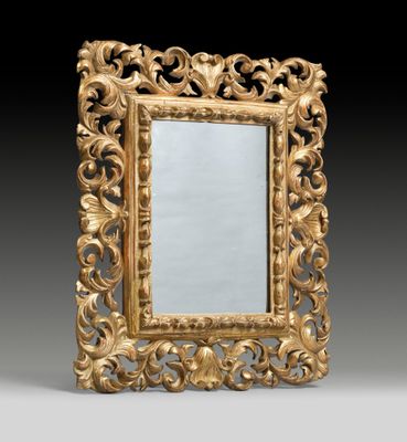 an ornately carved mirror with a gold frame on a black background