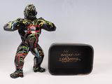 une figurine représentant un homme debout à côté d'une boîte