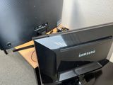 a black computer monitor sitting on a desk next to a computer monitor