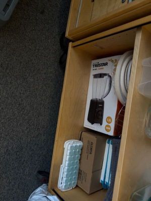 a wooden shelf with a blender and other items on top of it