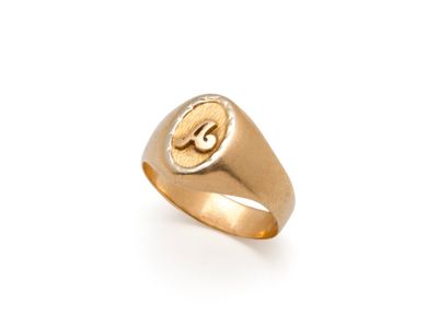 un gros plan d'une bague en or sur laquelle figure une lettre