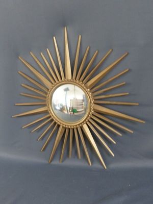 un miroir doré en forme d'étoile accroché au mur
