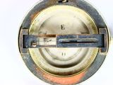 a close up of a compass on a white surface