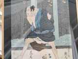 quelqu'un tient une photo d'un homme en kimono