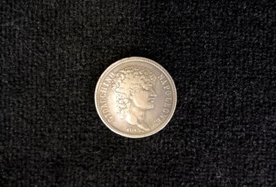 a close up of a silver coin on a black surface