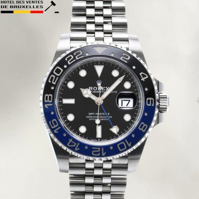 a close up of a wrist watch with a black dial and blue bezel