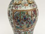 a vase with a painting on it sitting on a table