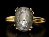 a close up of a gold ring with a gray diamond