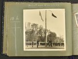 an old photo of a group of people standing in front of a flag pole
