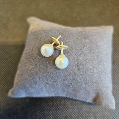 un gros plan sur une paire de boucles d'oreilles en perles posées sur un coussin