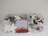 une boîte blanche remplie d'objets divers, posée sur une table blanche