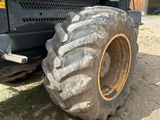 un gros tracteur garé sur un terrain en terre battue