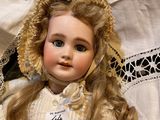 a close up of a doll with a bonnet on
