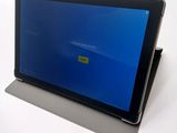 the tablet is sitting on a table with a blue screen on it