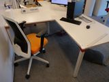 un bureau avec un ordinateur et une chaise dans un coin