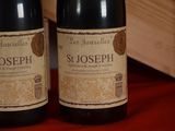 two bottles of wine sitting on a table next to each other