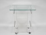 a clear glass side table with wheels on a white background
