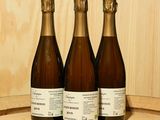 three bottles of wine sitting on top of a wooden barrel