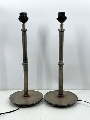 une paire de lampes de table en métal posées sur une surface blanche