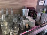 many empty glass bottles and cups on the counter