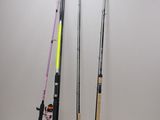 three fishing rods are lined up against a wall on a white surface
