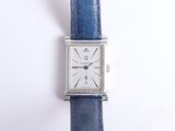 une image représentant une montre argentée avec un bracelet bleu sur un fond blanc