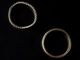 two gold wedding rings on a black background