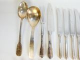 beaucoup d'argenterie et de couverts en argent sur une table blanche