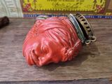 a red boxing glove on a wooden table next to a box of matches