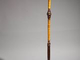 an old wooden stick with a wooden handle on a metal stand