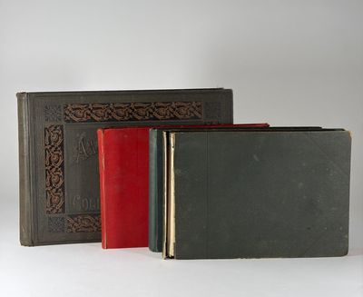 trois livres sont alignés sur une surface blanche